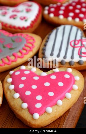 Biscotti assortiti appena sfornati a forma di cuore su legno breadboard Foto Stock