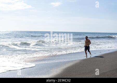 Giovane uomo che fa un allenamento in spiaggia Foto Stock