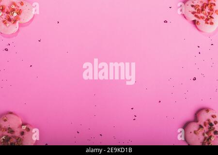 San Valentino biscotti a forma di cuore fragole secche su sfondo rosa con confetti. Vista dall'alto. Spazio di copia. Concetto d'amore, dolcetti di San Valentino Foto Stock