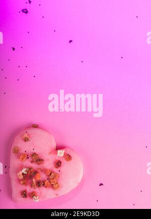 San Valentino biscotti a forma di cuore fragole secche su sfondo rosa con confetti. Vista dall'alto. Spazio di copia. Concetto d'amore, dolcetti di San Valentino Foto Stock