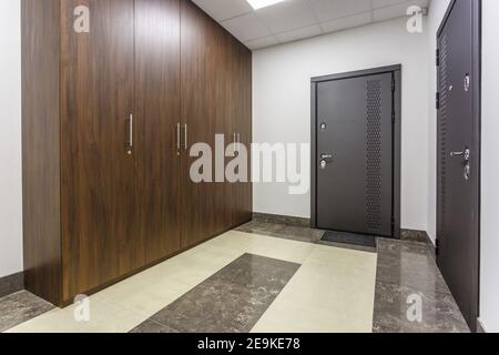 corridoio vuoto per camere all'interno di appartamenti moderni, uffici o cliniche con molte porte in metallo Foto Stock