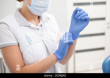 Donna medico indossando guanti di gomma, lavorando in ospedale Foto Stock