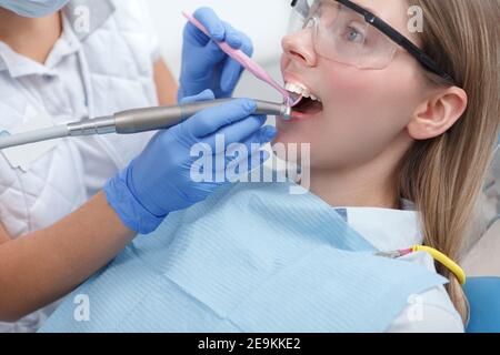 Ripresa tagliata di una paziente femminile che indossa occhiali protettivi che duono trattamento dentale Foto Stock