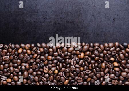 Chicchi di caffè su sfondo scuro, disposti in modo ordinato, close-up still life, flat lay, studio interno, sfondo, carta da parati con spazio per la copia, spazio per il testo Foto Stock