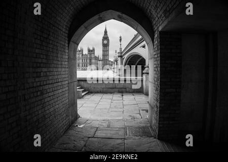 Vista in bianco e nero del Big ben e del Palazzo di Westminster da un passaggio sotto il ponte di Westminster, Londra, Inghilterra Foto Stock