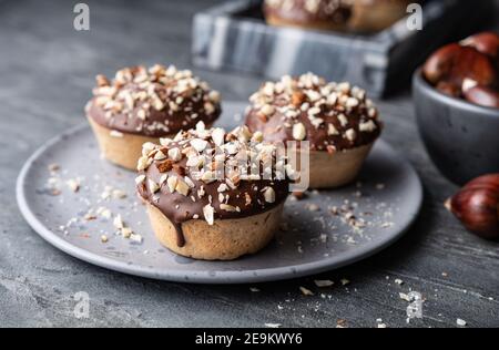 Coppe di castagne dolci farcite con formaggio a pasta morbida, purea di castagne e mandorle macinate, condite con glassa di cioccolato e noci tritate su backgrou di pietra Foto Stock