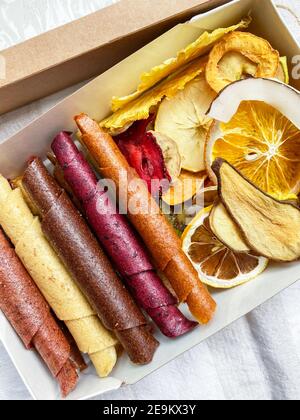 Dolci sani - pelle di frutta e patatine di frutta. Dolce pura pastiglia di frutta in panini. Dolci naturali di frutti di bosco e frutta. Disposizione piatta. Primo piano. Foto Stock