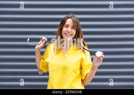 Ritratto di dottore caucasico in uniforme mostrando stetoscopio. Spazio per il testo. Foto Stock