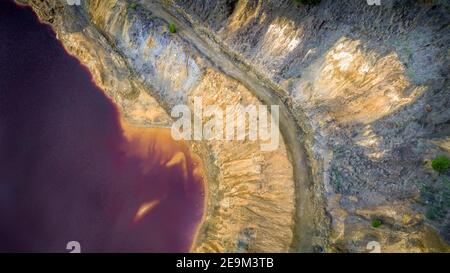 Lago rosso a Mitsero, Cipro vista aerea dettaglio. I suoi colori innaturali rosso e giallo sono il risultato dell'estrazione del minerale di pirite in Kokkinopezoula aperto Foto Stock