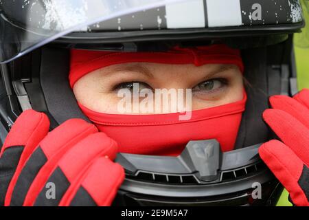 Immagine simbolo: Pilota di auto da corsa femminile con casco e balaclava (modello rilasciato) Foto Stock