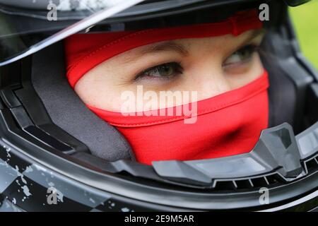 Immagine simbolo: Pilota di auto da corsa femminile con casco e balaclava (modello rilasciato) Foto Stock