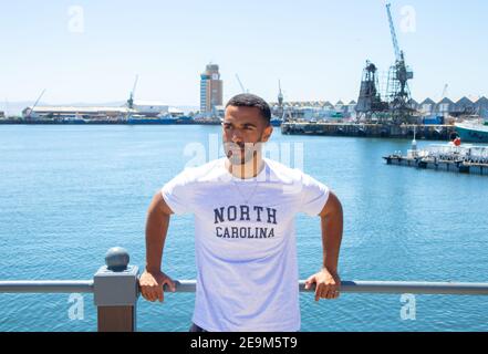 Waterfront - Città del Capo, Sud Africa - 03-02-2021 elegante uomo Capetoniano appoggiato sulla ringhiera al di fuori del Waterfront. Foto Stock