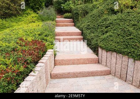 Cortile anteriore ordinato e ordinato con gradini a blocco solido, ghiaia decorativa e piantatura Foto Stock