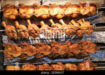 Filetto di maiale alla griglia (coscia di maiale arrosto) e arrostire il pollo sullo spiedo rotante Foto Stock