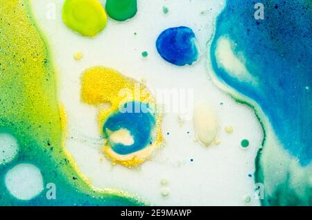 I colori acquarelli luminosi liquidi con olio generano strutture fluide e bolle in verde, blu, giallo, bianco e oro Foto Stock