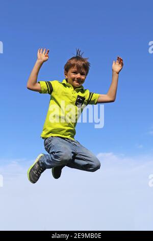 Immagine simbolo: Boy salta in aria, nel cielo blu di sfondo (modello rilasciato) Foto Stock