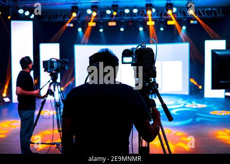 Cameraman professionale - copertura dell'evento con un video, una silhouette cameraman sulle notizie dal vivo in studio, fuoco selettivo Foto Stock