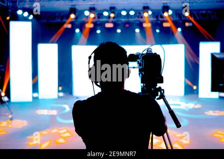 Cameraman professionale - copertura dell'evento con un video, una silhouette cameraman sulle notizie dal vivo in studio, fuoco selettivo Foto Stock