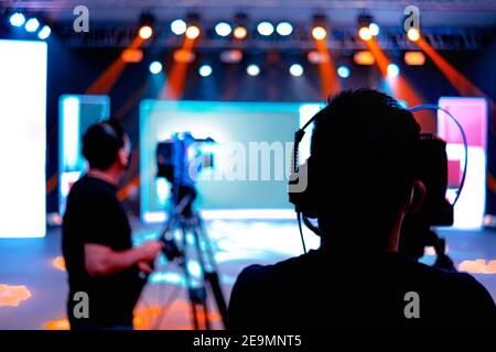 Cameraman professionale - copertura dell'evento con un video, una silhouette cameraman sulle notizie dal vivo in studio, fuoco selettivo Foto Stock