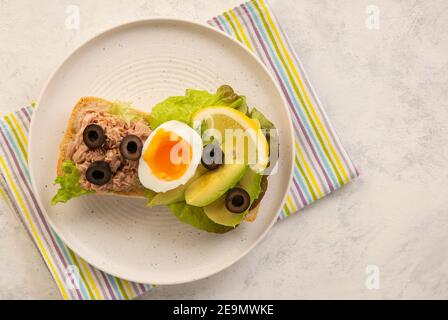 Panini con tonno, uova, olive e avocado su sfondo chiaro. Foto Stock