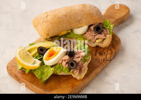 Panini con tonno, uova, olive e avocado su sfondo chiaro. Foto Stock