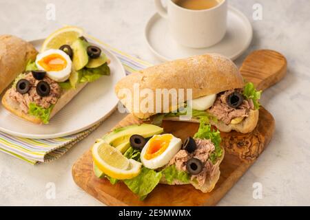 Panini con tonno, uova, olive e avocado su sfondo chiaro. Foto Stock