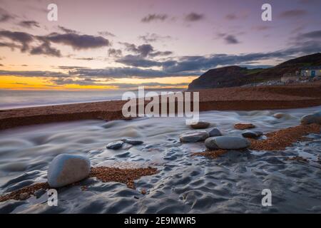 Seatown, Dorset, Regno Unito. 5 febbraio 2021. Regno Unito Meteo. Tramonto vista dalla spiaggia di Seatown in Dorset guardando verso le scogliere di Golden Cap alla fine di una giornata di incantesimi di sole. Picture Credit: Graham Hunt/Alamy Live News Foto Stock