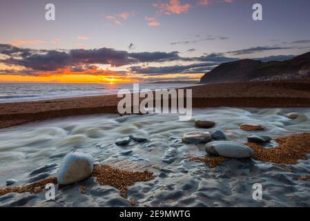 Seatown, Dorset, Regno Unito. 5 febbraio 2021. Regno Unito Meteo. Tramonto vista dalla spiaggia di Seatown in Dorset guardando verso le scogliere di Golden Cap alla fine di una giornata di incantesimi di sole. Picture Credit: Graham Hunt/Alamy Live News Foto Stock