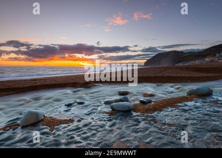 Seatown, Dorset, Regno Unito. 5 febbraio 2021. Regno Unito Meteo. Tramonto vista dalla spiaggia di Seatown in Dorset guardando verso le scogliere di Golden Cap alla fine di una giornata di incantesimi di sole. Picture Credit: Graham Hunt/Alamy Live News Foto Stock