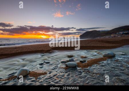 Seatown, Dorset, Regno Unito. 5 febbraio 2021. Regno Unito Meteo. Tramonto vista dalla spiaggia di Seatown in Dorset guardando verso le scogliere di Golden Cap alla fine di una giornata di incantesimi di sole. Picture Credit: Graham Hunt/Alamy Live News Foto Stock