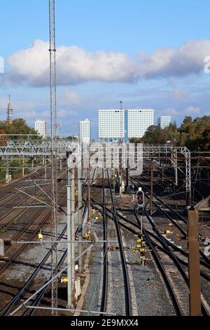 Ferrovia a Helsinki, Finlandia. Fotografato Sep, 2019. Numerosi binari ferroviari con linee di alimentazione, alcuni alberi, cielo blu e il Mall of Tripla. Foto Stock
