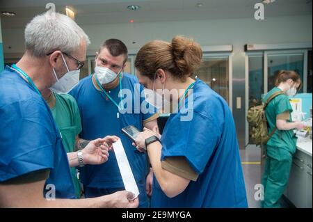 Lissabon, Portogallo. 05 febbraio 2021. I medici militari tedeschi parlano del rapporto sulle attrezzature mediche in portoghese durante una visita preparatoria all'Ospedale da Luz, mentre controllano la traduzione in tedesco sui loro telefoni cellulari. La Germania sostiene il Portogallo con un team di medici e paramedici della Bundeswehr. I 26 soldati sono in servizio in una clinica di Lisbona. Credit: Paulo Mumia/dpa/Alamy Live News Foto Stock