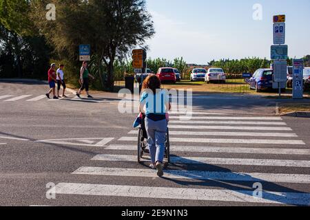 Strunian, Slovenia - Settembre 19: Assistente che aiuta la persona disabile su una sedia a rotelle ad attraversare la traversata della zebra il 19 settembre 2020 Foto Stock