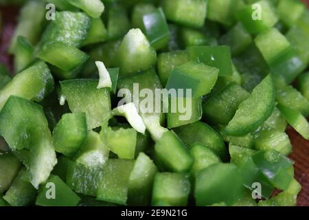 Preparazione degli alimenti per la cottura: Pezzetti di pepe verde tritati in un primo piano. Verdure sane da usare per un'insalata o un'omelette. Cucina casalinga. Foto Stock