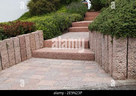 Cortile anteriore ordinato e ordinato con gradini a blocco solido, ghiaia decorativa e piantatura Foto Stock