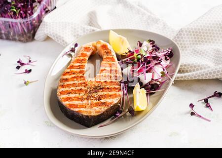 Salmone. Bistecca di pesce al salmone alla griglia e insalata di ravanello con micrograni. Cibo sano. Foto Stock