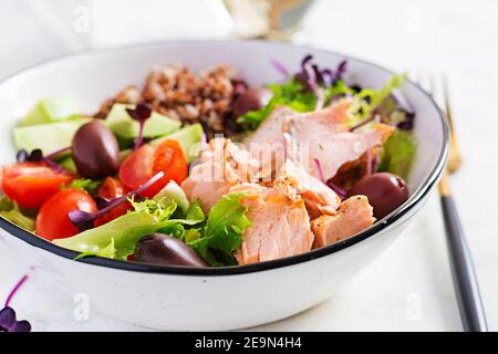 Insalata di salmone. Insalata fresca con salmone alla griglia, avocado, pomodori ciliegini, lattuga, quinoa, olive e micrograni. Cibo fatto in casa. Concetto pasto sano Foto Stock