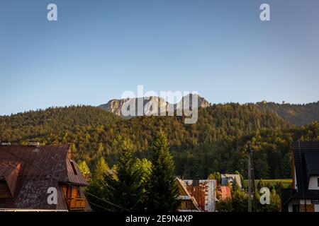 Monte Giewont (Cavaliere dormiente) Con foresta di conifere in montagna Tatra in Polonia e tradizionale architettura delle montagne polacche in un'ora d'oro Foto Stock