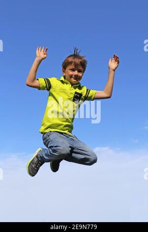 Immagine simbolo: Boy salta in aria, nel cielo blu di sfondo (modello rilasciato) Foto Stock