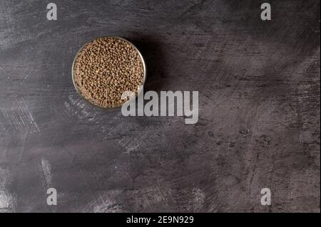 dettaglio di un vaso di vetro riempito con lenticchie contro a. sfondo scuro Foto Stock