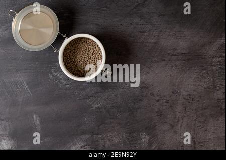 particolare di un vaso bianco in ceramica con coperchio con lenticchie interno su sfondo scuro Foto Stock