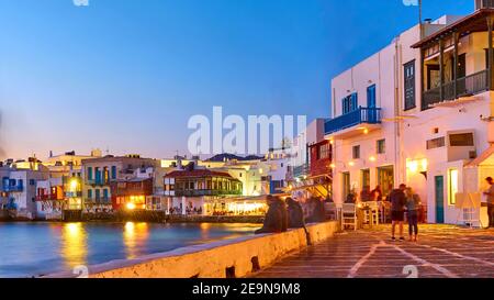 Il piccolo quartiere di Venezia con bar e ristoranti sul mare nell'isola di Mykonos al tramonto, in Grecia. Località greca di notte Foto Stock