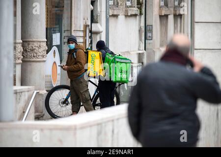 Lisbona, Portogallo. 5 Feb 2021. Uber mangia e i corrieri di Glovo hanno visto in attesa di prendere gli ordini in un ristorante a Lisbona. La pandemia ha innescato il numero di corrieri che lavorano sulle piattaforme di consegna di cibo. Nel centro di Lisbona, molte persone scelgono di effettuare consegne su biciclette e scooter elettrici sfruttando la rete di piste ciclabili. Credit: Hugo Amaral/SOPA Images/ZUMA Wire/Alamy Live News Foto Stock