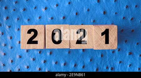 2021 nuovo anno su cubetti di legno su fondo di pelle rossa. Concetto di radulazione NY. Foto Stock