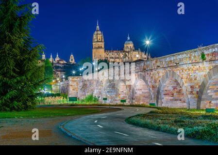 Vista al tramonto del ponte romano che conduce alla cattedrale di Salamanca, Spagna Foto Stock