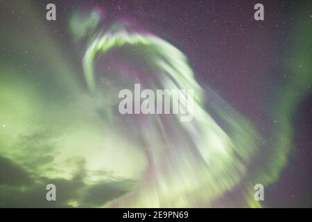 Aurora boreale su lago ghiacciato e innevato Foto Stock