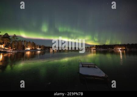 aurora boreale su lago ghiacciato e innevato Foto Stock