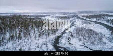 foresta ghiacciata e fiume da vista aerea in panoramica Foto Stock
