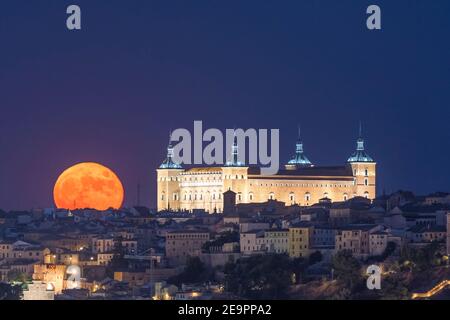 Luna piena sulla città vecchia. Castello storico, Alcazar di Toledo Foto Stock