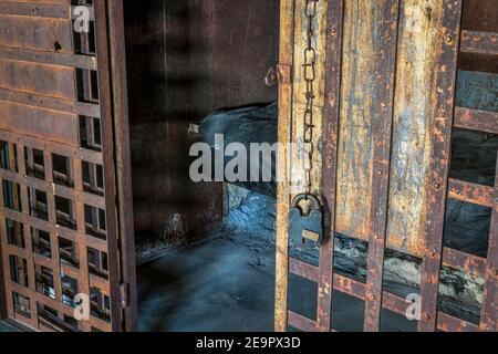 cella di prigione vintage vuota con barre arrugginite e serratura Foto Stock